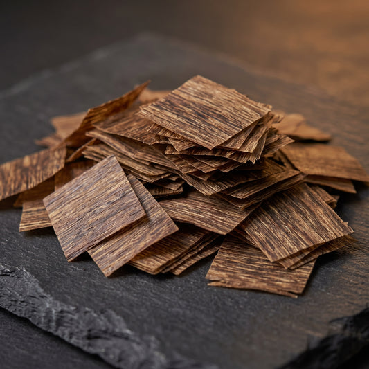 A pile of square-cut Vietnamese oud incense chips stacked on a dark slate surface.